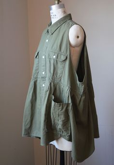 Olive green button down sleeveless smock with large arm holes and large pockets.  Smock has an asymmetrical hem. Made from a deconstructed vintage Levi's button down shirt. 100% Cotton Tag says XXL.  It would fit a range of sizes, depending on how loose or snug you prefer.  Please see measurements below: Measurements (taken w/jacket laid flat): Across chest at underarm: 28.5" Across hem: 48" Shoulder to hem: 30" I like to re-purpose clothing from the thrift store, as opposed to always buying new fabric. It is a challenge to work out the designs and feels like a small way to fight "Fast Fashion". Deconstructed Shirt, Button Down, Green Button, Asymmetrical Hem, Vintage Levis, Fast Fashion, Dress Clothes For Women, Asymmetric Hem, Thrift Store