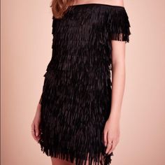 Swish And Swoosh In This Fringed Mini. It’s A Playful, Party-Ready Option You’ll Turn To All Season Long. Off-Shoulder Neckline Laser Cut Poly Fringe Sheath Silhouette Mini Length Center Back Invisible Zip Lined In Soft Jersey Dry Clean Flirty Fringe Mini Dress For Party, Holiday Fringe Dresses For Night Out, Flirty Fringe Mini Dress, Holiday Party Dress With Fringe, Fringe Mini Evening Dress, Black Fringe Mini Dress For Party Season, Chic Evening Mini Dress With Fringe, Chic Fringe Mini Dress For Night Out, Black Fringe Mini Dress For Cocktail