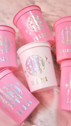 pink cups with disco designs on them sitting on a marble countertop in front of the camera