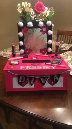 a valentine's day gift box with flowers and cell phones in it sitting on a table