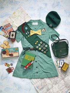 an assortment of items laid out on top of a map, including a green shirt and hat