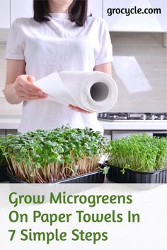 a woman holding a roll of paper over some plants