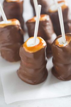 chocolate covered marshmallows on a plate with toothpicks sticking out of them