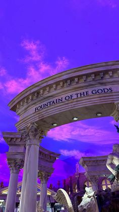 the fountain of the gods in las vegas, nevada is lit up with purple and blue skies