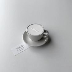 a cup and saucer with a business card on it