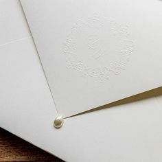 two white envelopes with embosishment on them