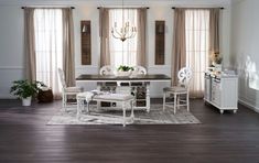 a dining room table with white chairs and a chandelier