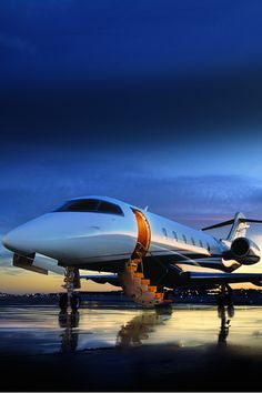 an airplane sitting on the tarmac at dusk