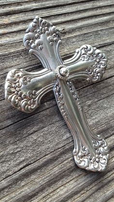 a metal cross sitting on top of a wooden table