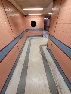 an empty hallway with blue and pink walls