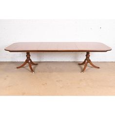 a large wooden table with two pedestals on one end and an oval shaped top