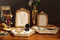 a table topped with jewelry and a vase filled with white flowers on top of it