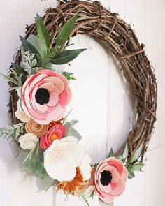 a wreath with flowers is hanging on the door