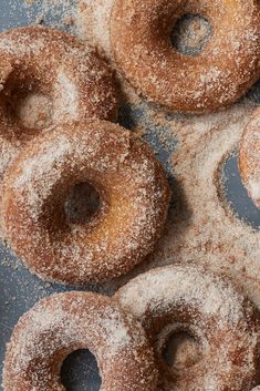 powdered sugar covered donuts sitting on top of a table