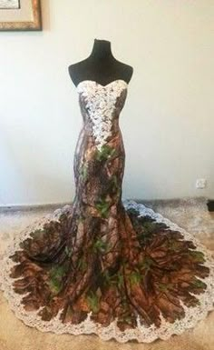 a dress made out of pine cones is on display in front of a framed photo