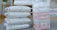 a pile of white bags sitting on top of a wooden floor next to a bed