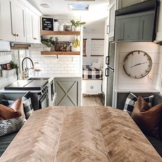 a kitchen and dining area in a small home with white cabinets, wood counter tops, and an open floor plan