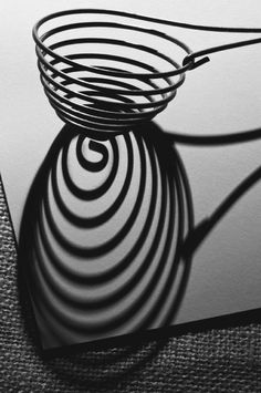 the shadow of an object is cast on top of a piece of paper with a spiral design