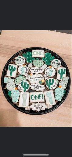 some cookies are arranged in the shape of cactuses on a plate with words and numbers