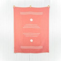 an orange and white towel hanging on a wall with two dots in the middle of it