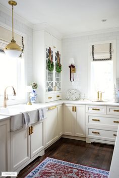 a kitchen with white cabinets and gold pulls on the cupboards is pictured in this image