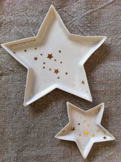 two white dishes with gold stars on them