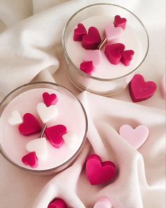 two bowls filled with hearts on top of a white table cloth next to each other