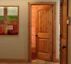 two doors are open in a room with tile flooring and wood paneling on the walls