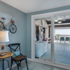 a room with a bicycle mounted to the wall and sliding glass doors that lead outside