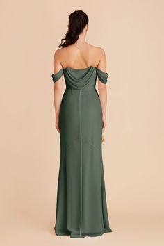 the back of a woman wearing a green dress with one shoulder draped over her shoulders