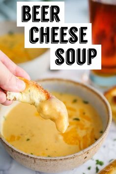 a person dipping some bread into a bowl of beer cheese soup