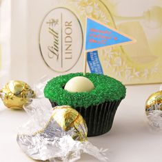 a cupcake decorated with grass and an egg