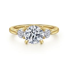 three stone engagement ring in yellow gold with diamonds on the sides and an accent band