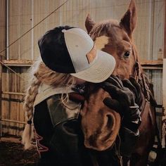 a person hugging a horse in a barn