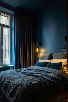 a bed sitting next to a large window in a room with blue walls and curtains