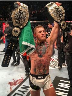 the man is holding his arms up in victory with two flags on each side of him