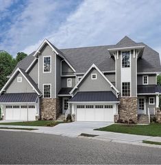 a large gray and white house with two garages