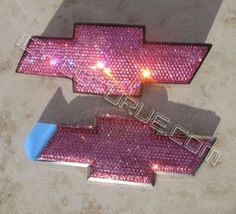 a pair of pink sequinized chevy emblems