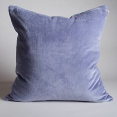 a blue velvet pillow on a white background