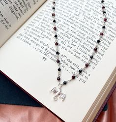 an open book with a necklace on it