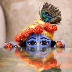 a close up of a face on a table with a peacock sitting on top of it