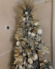 a christmas tree with gold and silver decorations