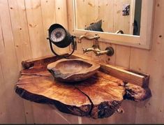 a bathroom sink made out of a tree stump with a mirror and faucet