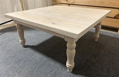 a wooden table sitting on top of a carpeted floor