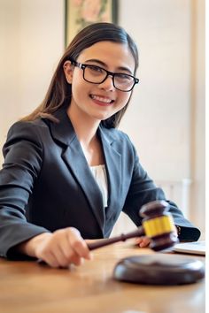 a woman sitting at a table with a judge's gavel