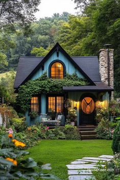 a blue house surrounded by greenery and flowers