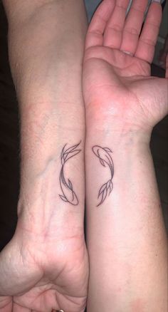 two people holding hands with tattoos on their arms and one has a fish in it