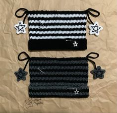 two black and white crocheted bags with stars on them sitting on a brown sheet