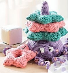 an octopus stuffed animal sitting on top of a table next to pillows and a pillow