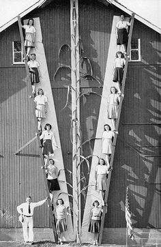 an old black and white photo shows people climbing up the side of a building